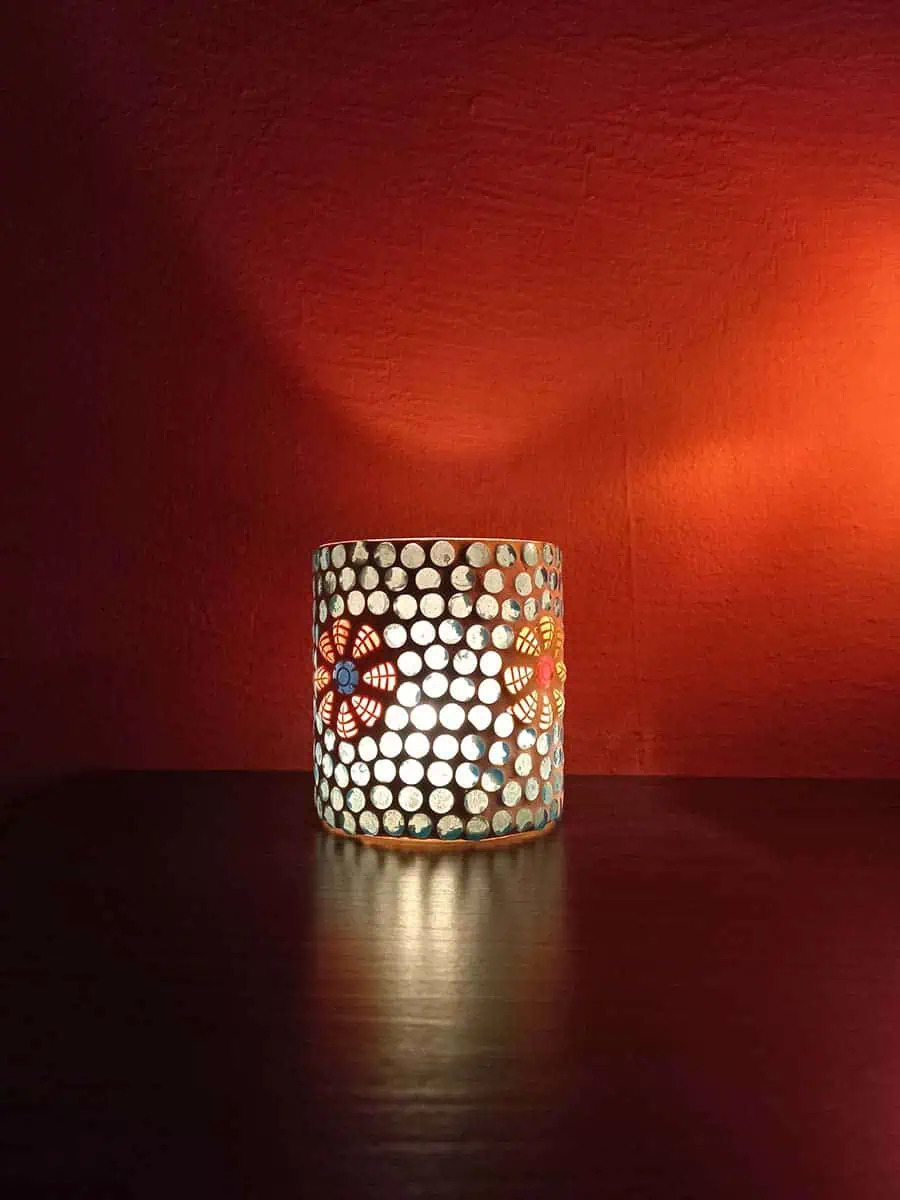 Portavela de vidrio celeste con flores