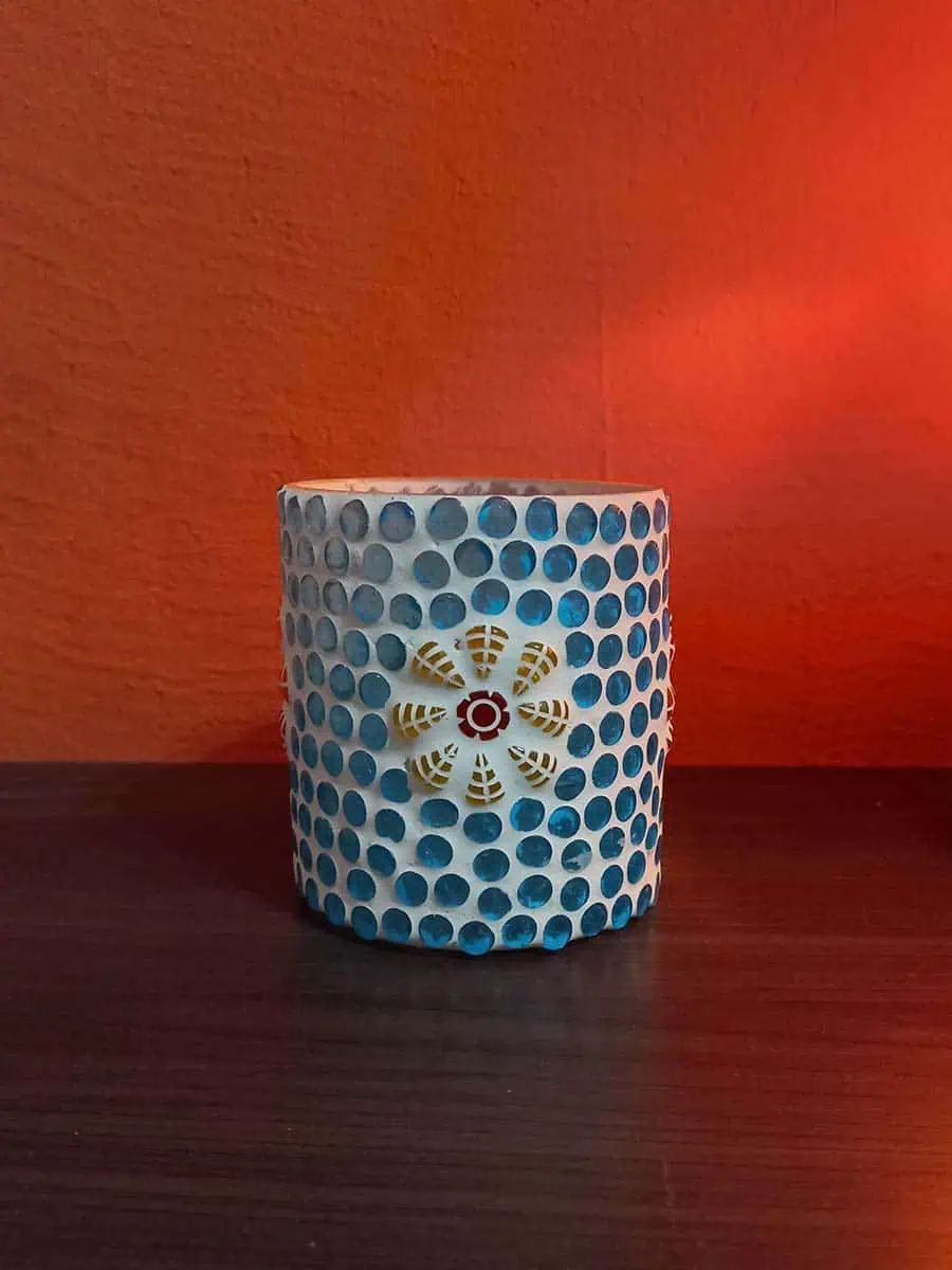 Portavela de vidrio celeste con flores