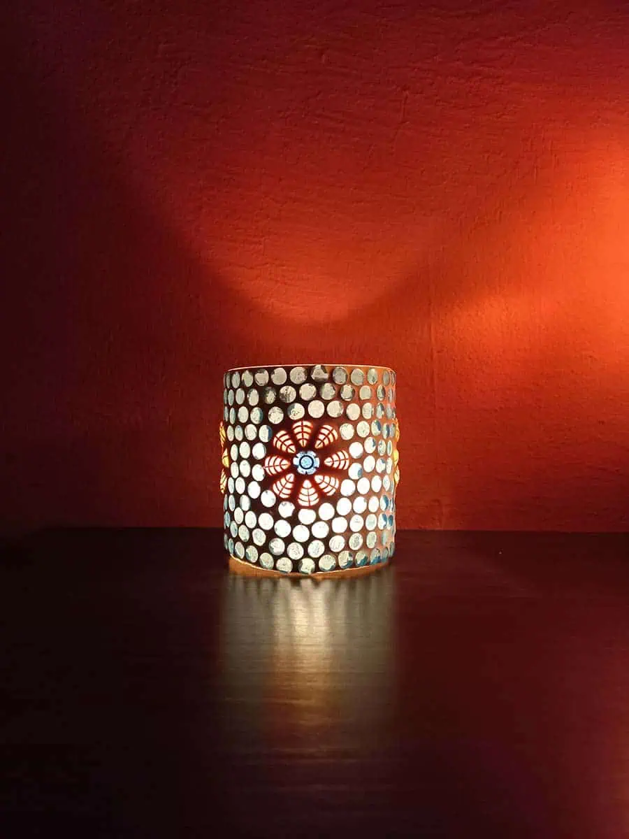 Portavela de vidrio celeste con flores