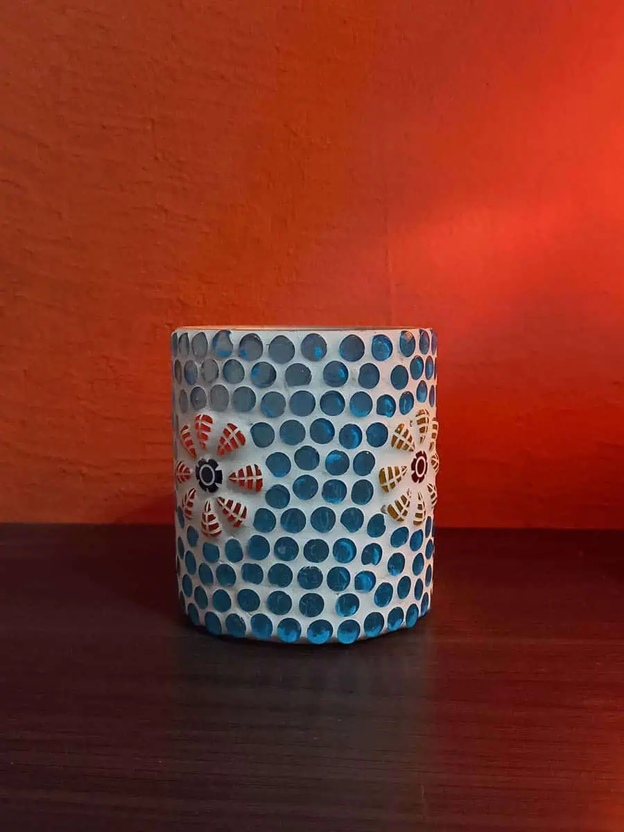 Portavela de vidrio celeste con flores