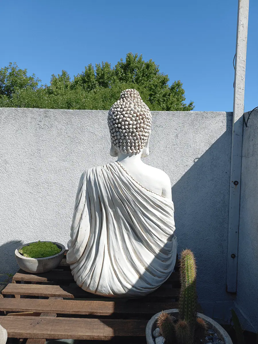 Buda de resina para exterior grande de meditacion decorando un espacio zen
