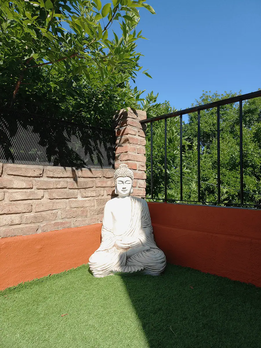 Buda de resina para exterior grande de meditacion decorando un espacio zen