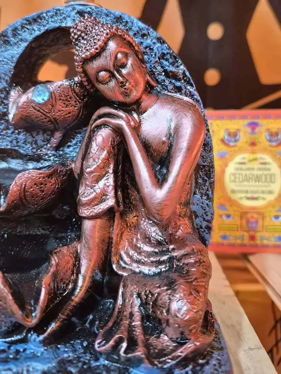 Cascada de humo para conos de reflujo con figura de Buda sentado y cuencos escalonados en tonos cobrizos
