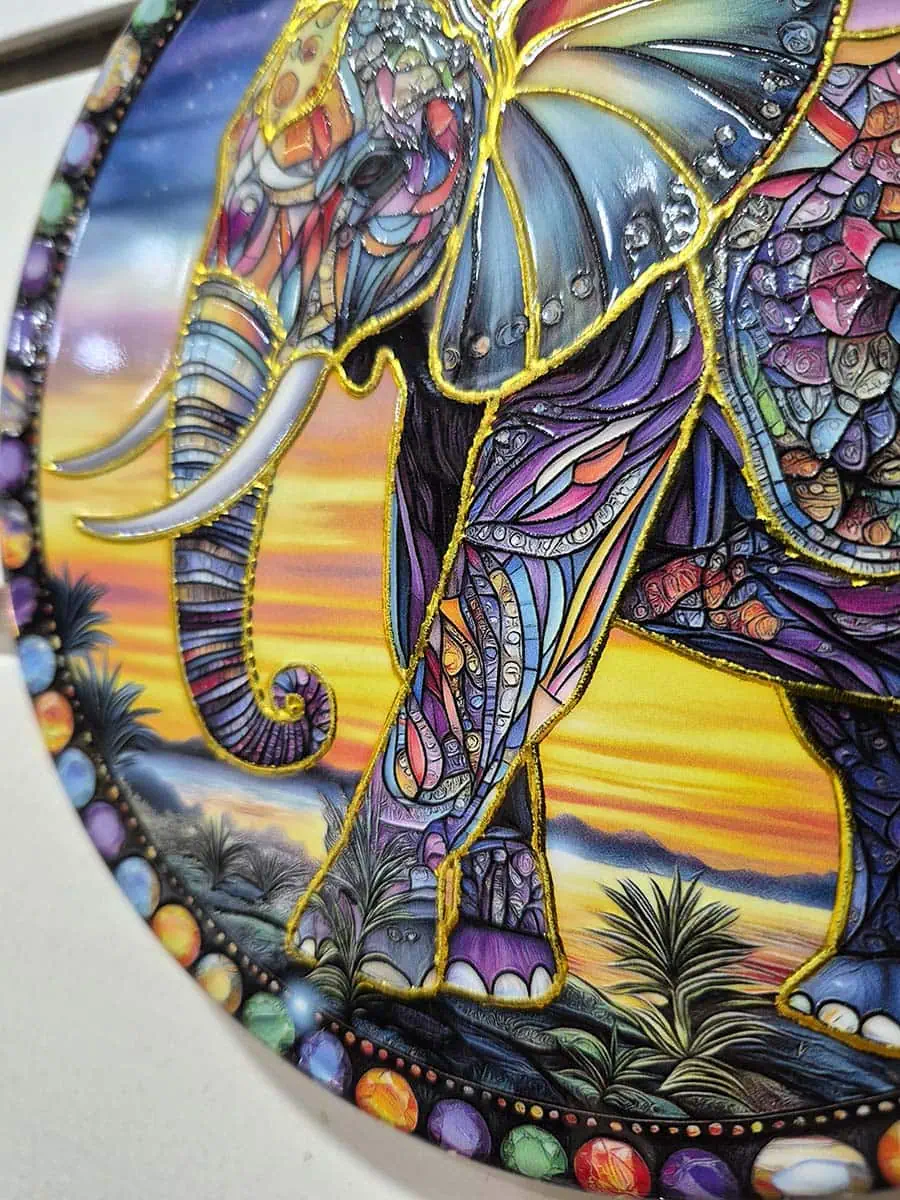 Colgante de pared redondo de cerámica con elefante colorido sobre un paisaje de anochecer
