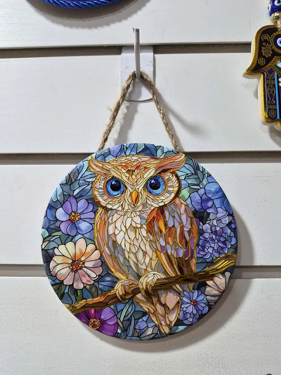 Colgante decorativo de pared de cerámica con una lechuza en tonos cálidos anaranjados, dorados y turquesas