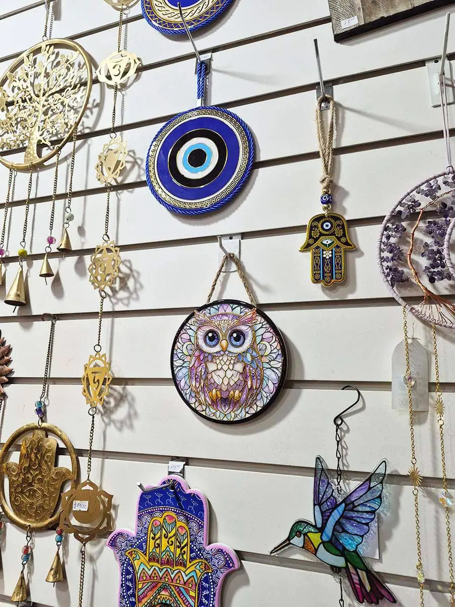Colgante de pared redondo de cerámica con una lechuza en tonos violetas y azules sobre un fondo colorido