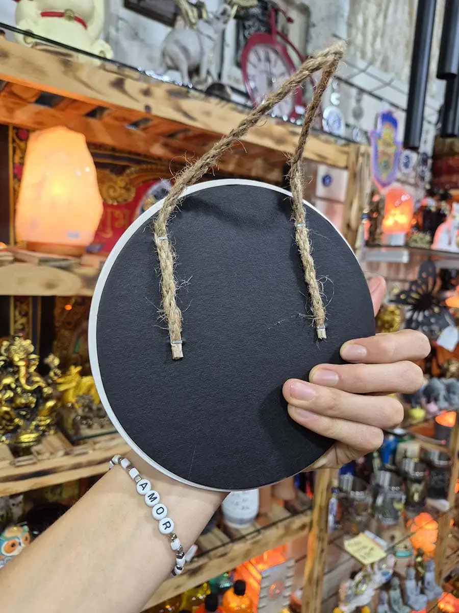 Colgante decorativo redondo de cerámica con Mano de Fátima azul, ojo turco y detalles florales sobre fondo naranja