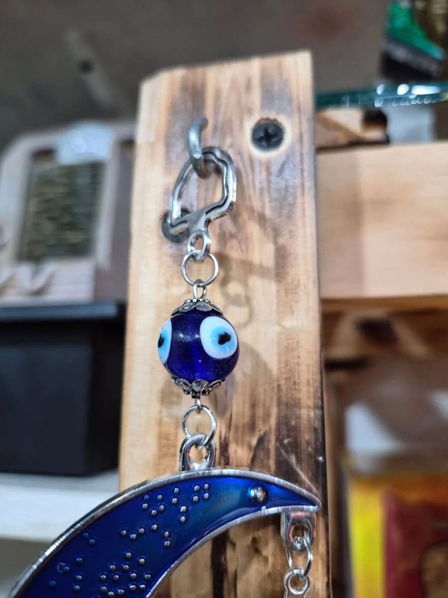 Colgante de luna creciente azul con rostro, elefante plateado, pequeños ojos turcos y disco protector inferior