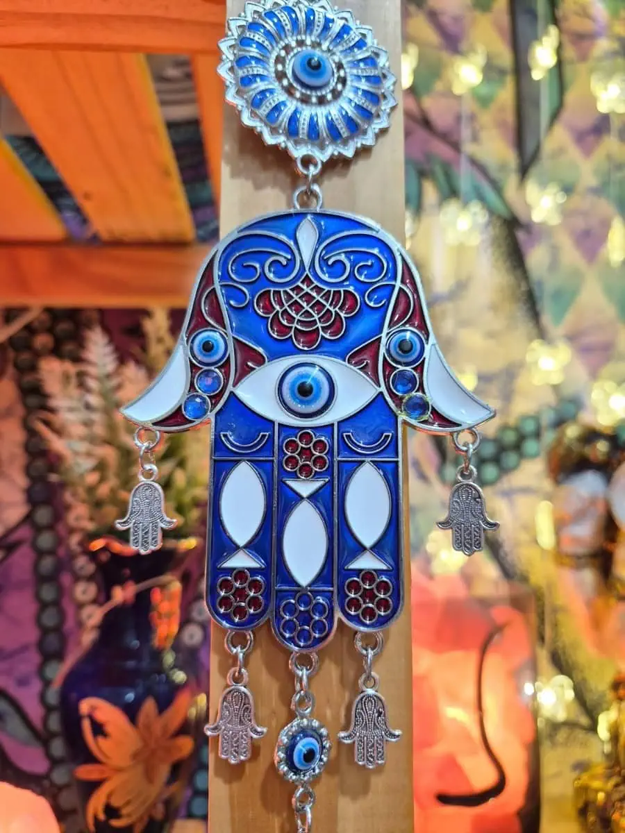 Mano de Fátima azul y blanca con dibujos geométricos, ojo turco central, pequeñas manos colgantes y disco azul inferior
