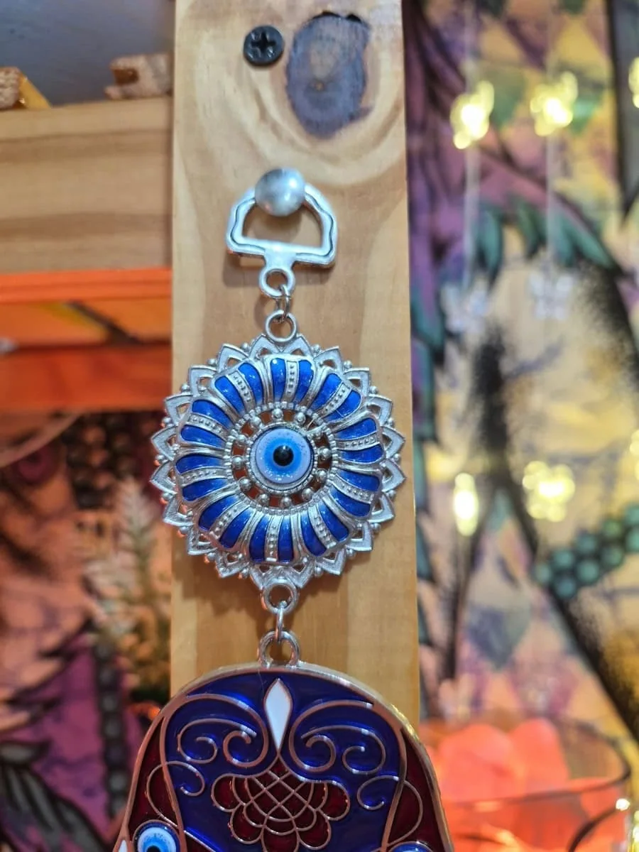 Mano de Fátima azul y blanca con dibujos geométricos, ojo turco central, pequeñas manos colgantes y disco azul inferior