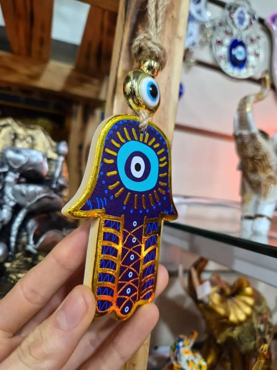 Colgante Mano de Fátima azul intenso con ojo turco blanco y celeste, dibujos dorados y cordón de soga
