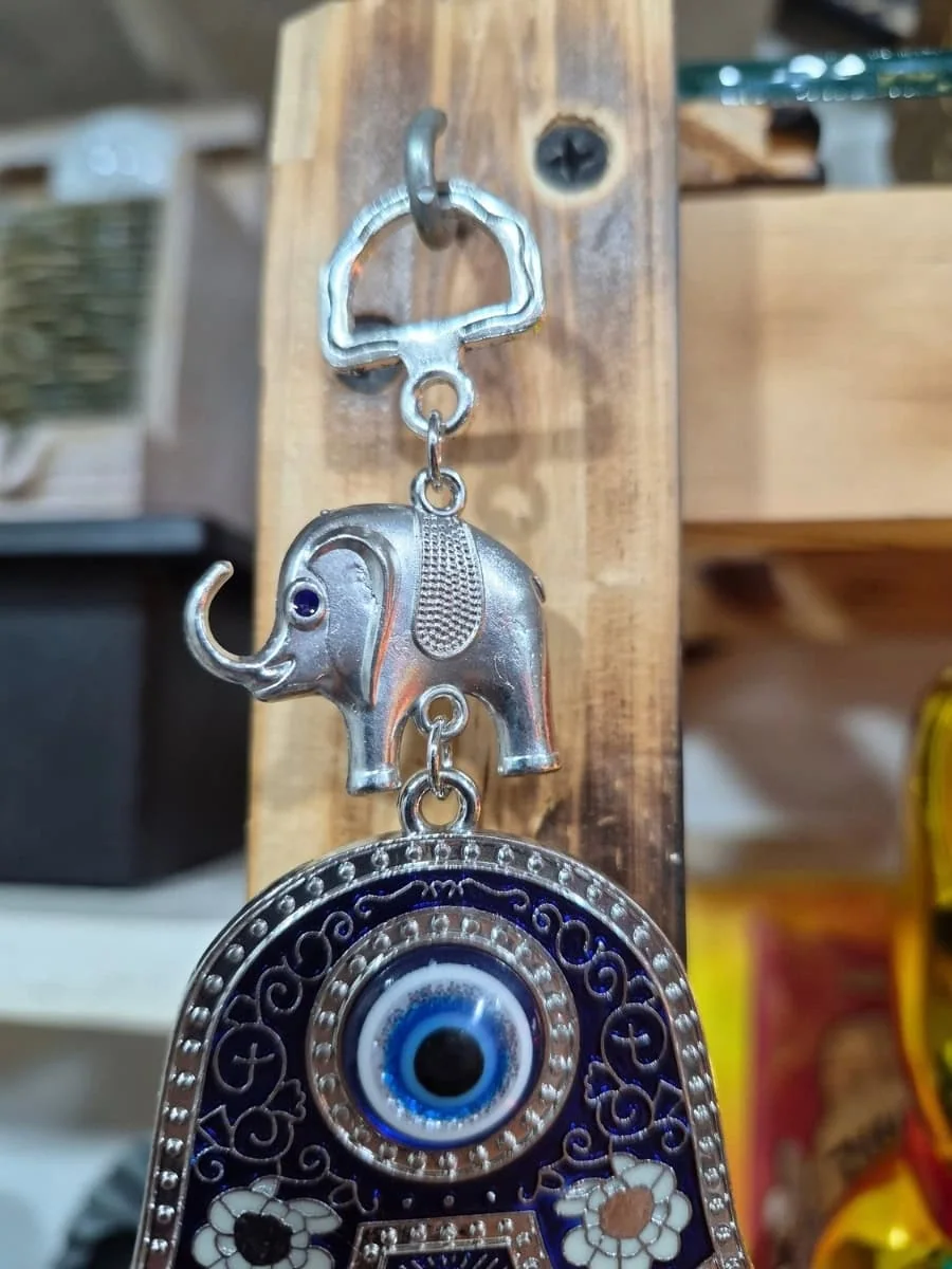 Colgante de Mano de Fátima azul oscuro y plateada con dibujos ornamentales, elefante superior y ojo turco colgante