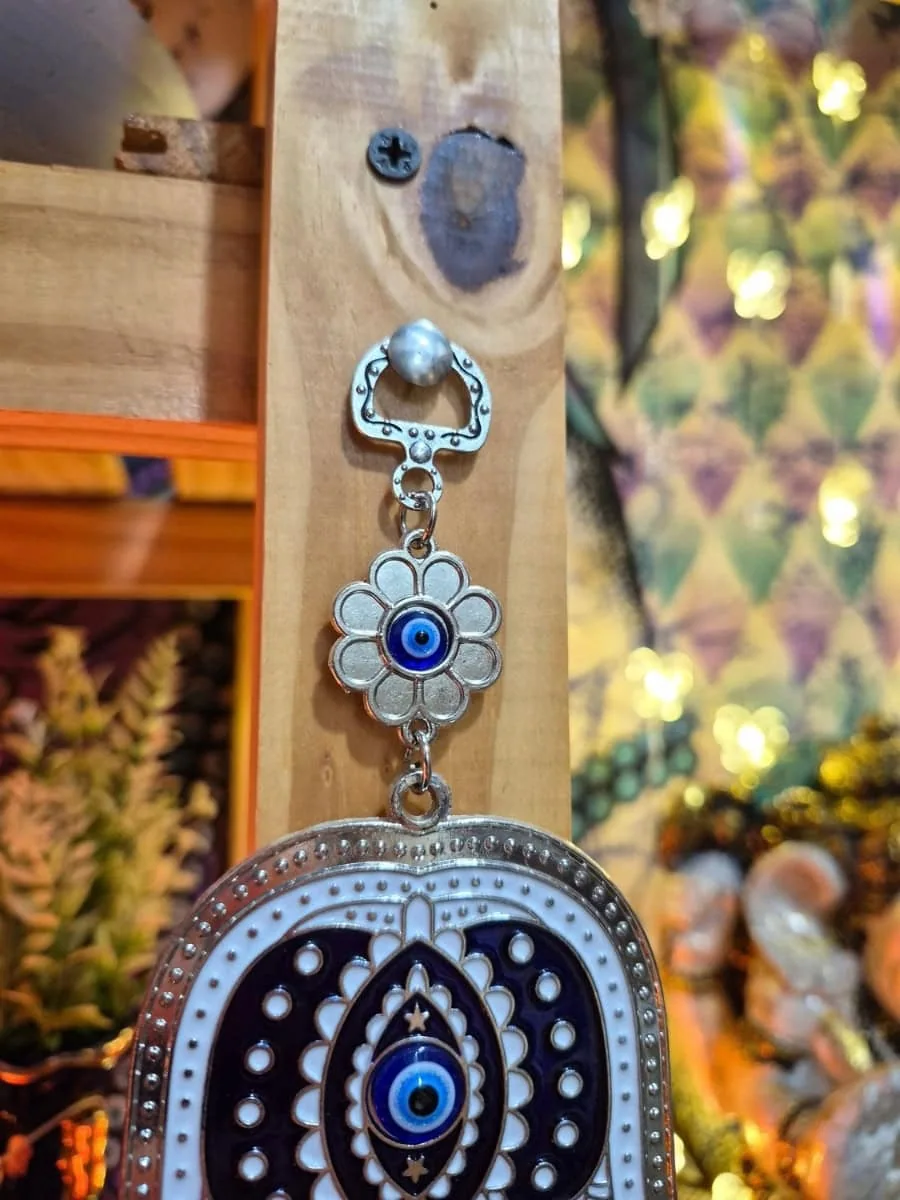 Colgante Mano de Fátima celeste y plateada con dibujos azules, pequeños elefantes laterales y ojo turco inferior