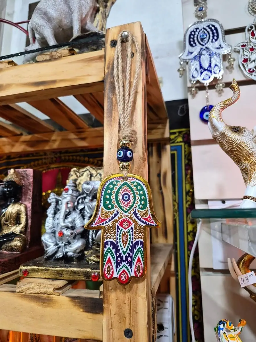 Colgante de pared Mano de Fátima multicolor con dibujos verdes, rojos y violetas, ojo turco azul y cordón de soga