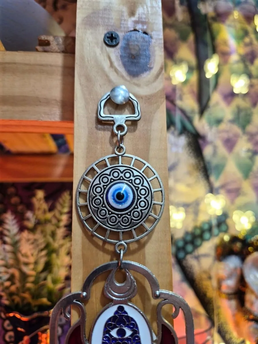 Mano de Fátima plateada calada con motivos florales rojos, pequeño símbolo Hamsa y ojo turco azul grande central