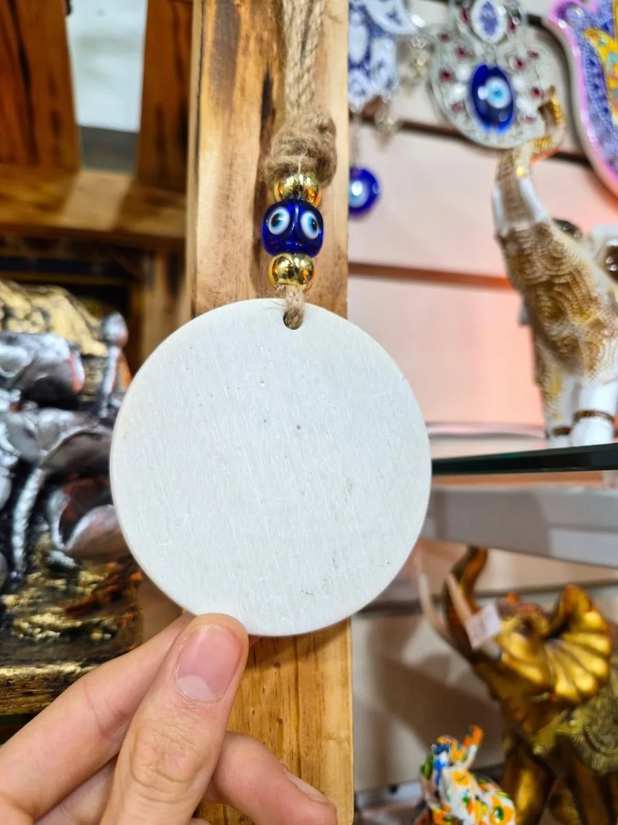 Colgante circular violeta con símbolo Om celeste, borde de flores doradas y cuenta de ojo turco azul