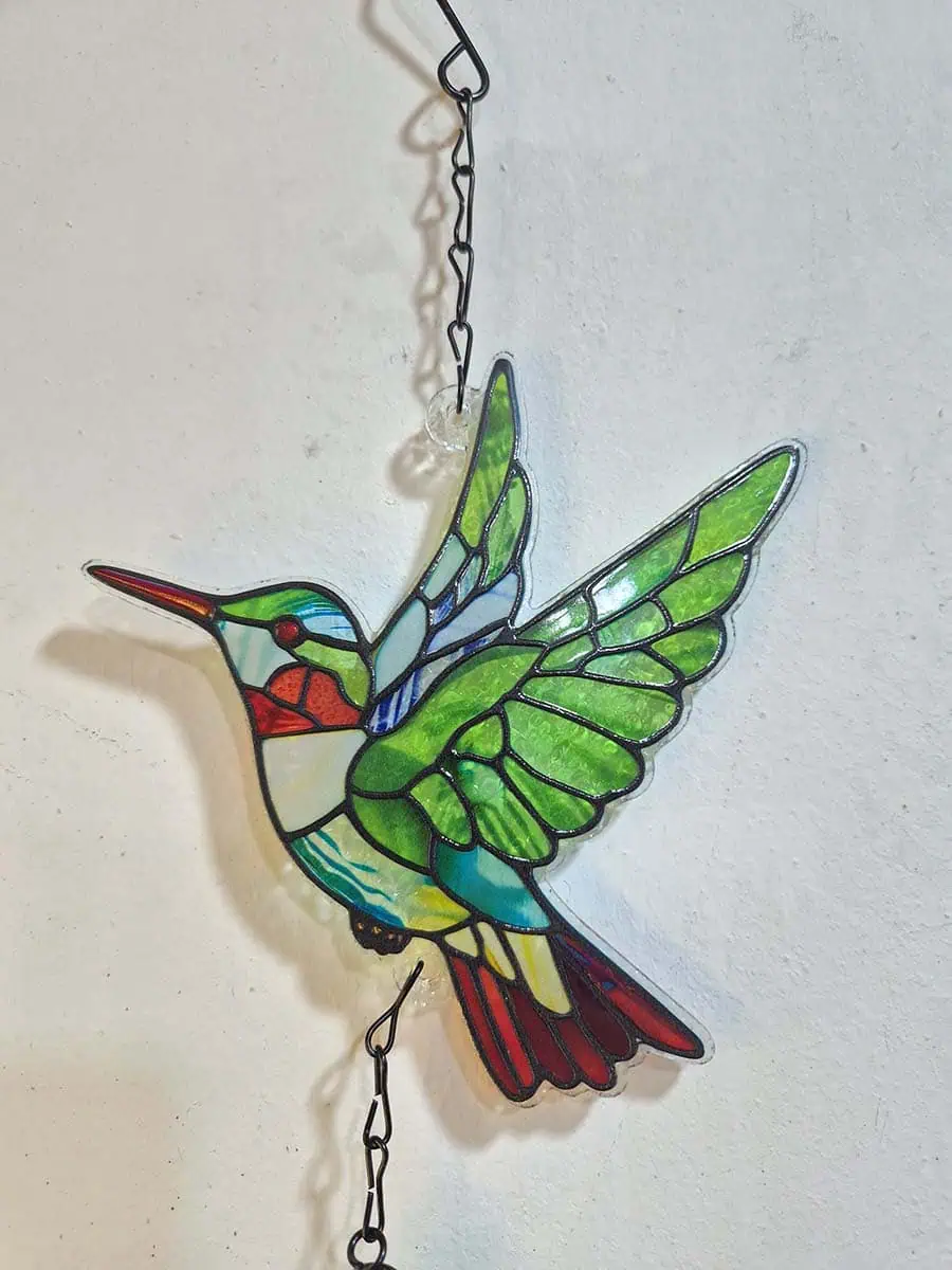 Colgante decorativo de colibrí en vitró verde con detalles rojos y campana de metal