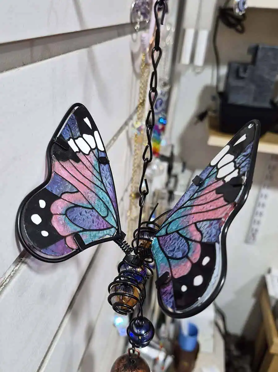 Colgante decorativo de mariposa en vitró lila, celeste y rosa con alas tridimensionales y campana de metal