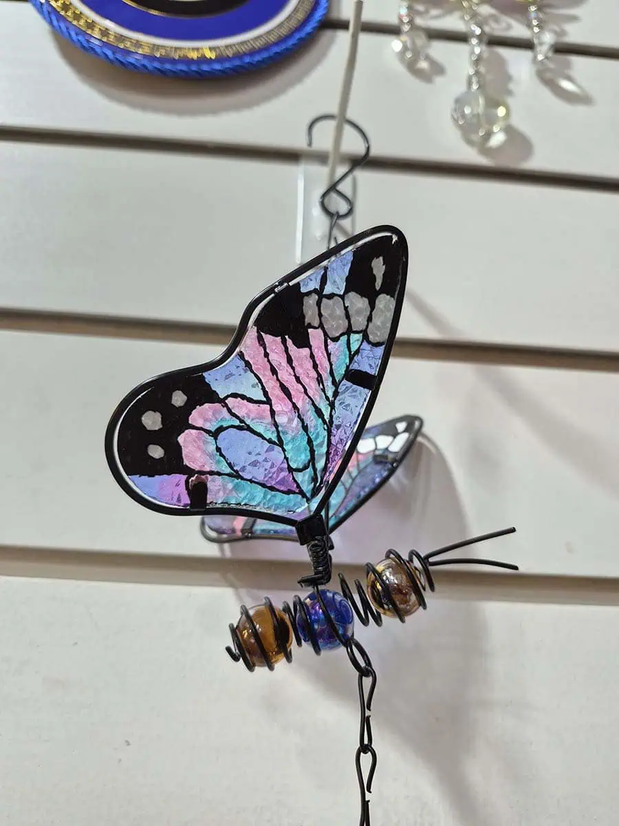 Colgante decorativo de mariposa en vitró lila, celeste y rosa con alas tridimensionales y campana de metal