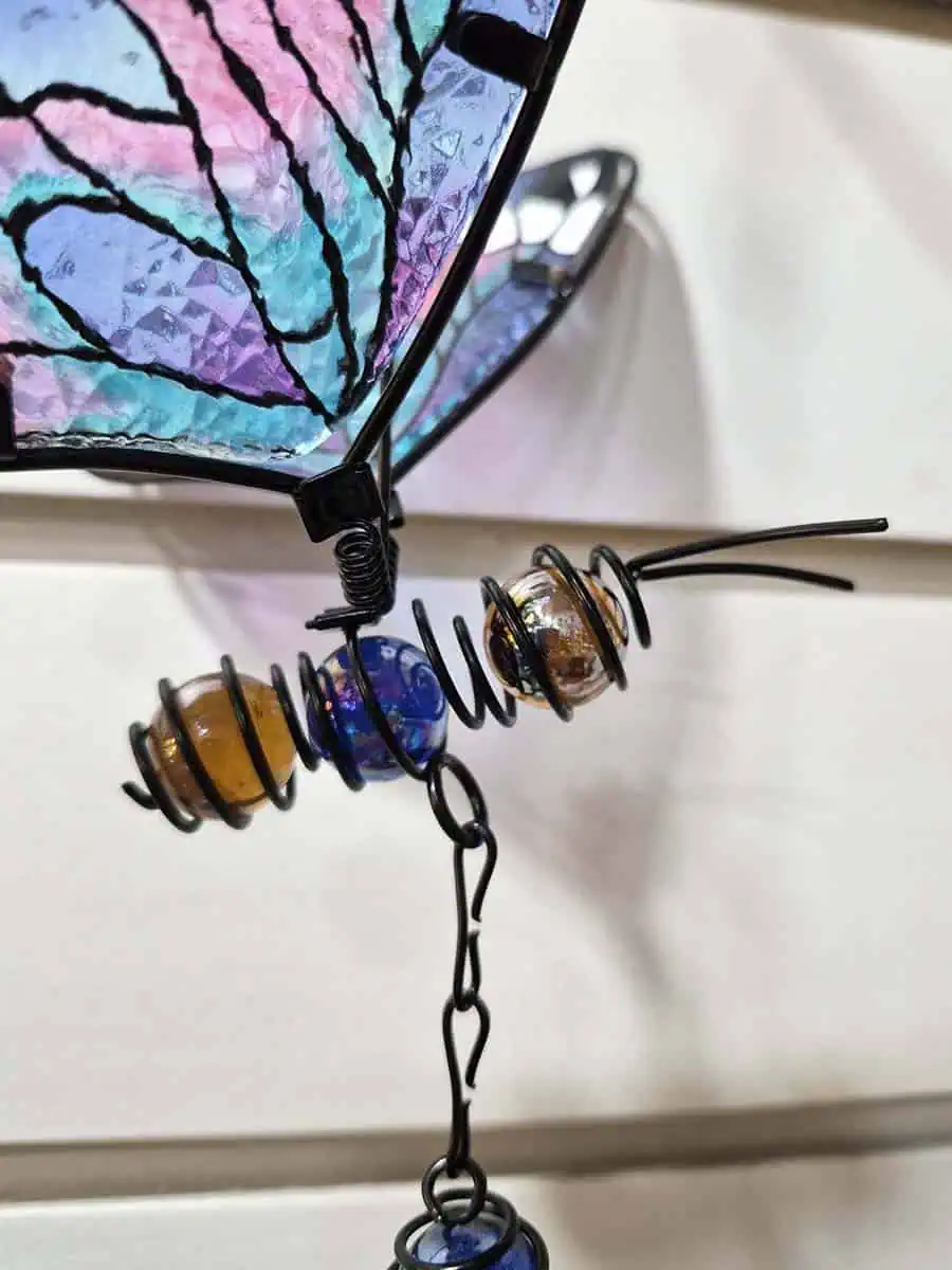 Colgante decorativo de mariposa en vitró lila, celeste y rosa con alas tridimensionales y campana de metal