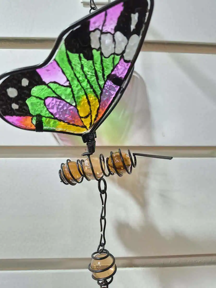 Colgante decorativo de mariposa en vitró verde y rosa con alas tridimensionales y campana de metal