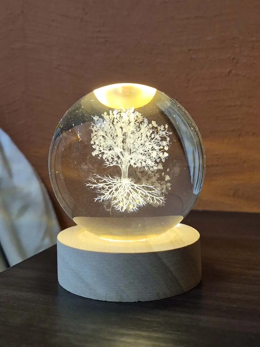 Lámpara esfera de cristal 3D con Árbol de la Vida iluminado sobre base de madera