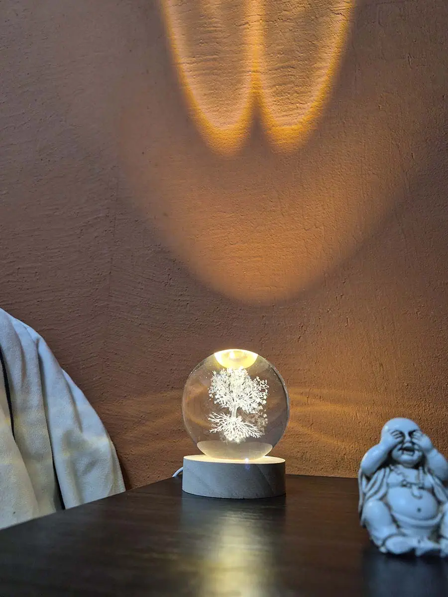 Lámpara esfera de cristal 3D con Árbol de la Vida iluminado sobre base de madera