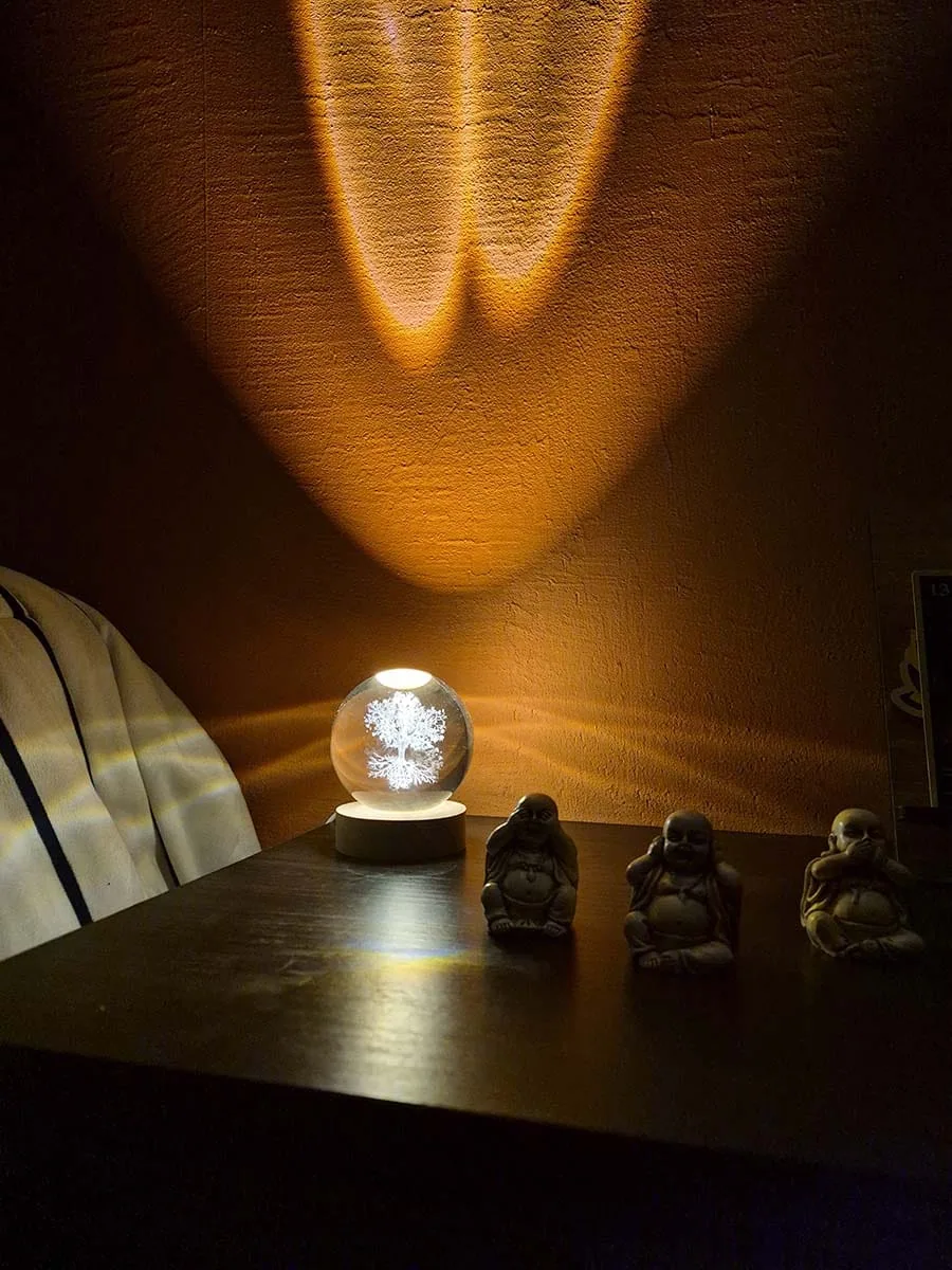 Lámpara esfera de cristal 3D con Árbol de la Vida iluminado sobre base de madera