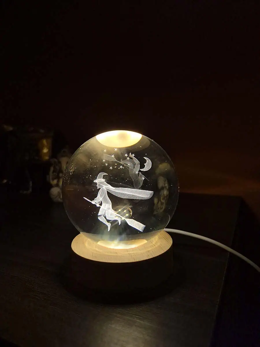 Lámpara esfera de cristal 3D con bruja volando en escoba y luz cálida