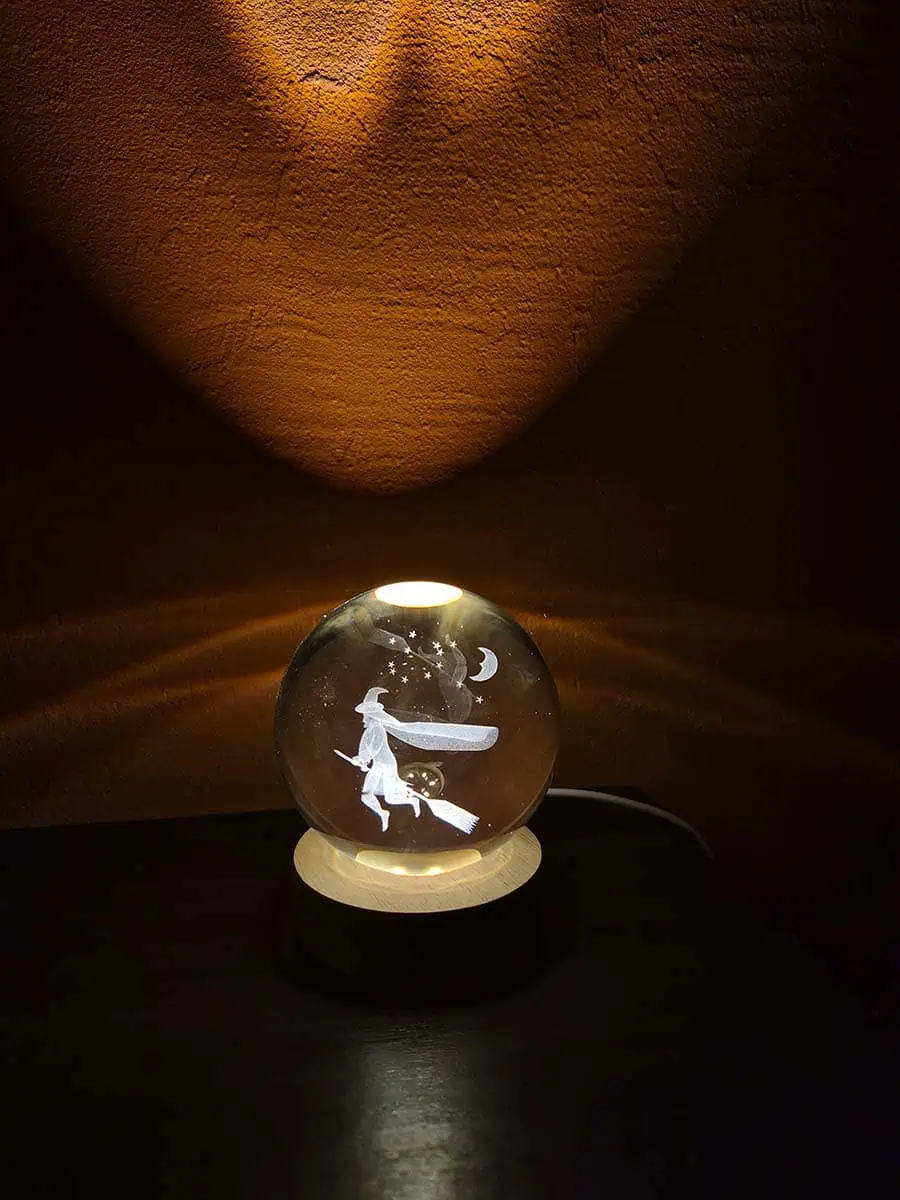Lámpara esfera de cristal 3D con bruja volando en escoba y luz cálida