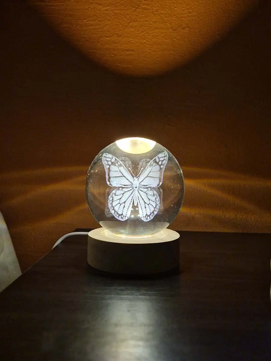Lámpara esfera de cristal 3D con mariposa iluminada y base de madera