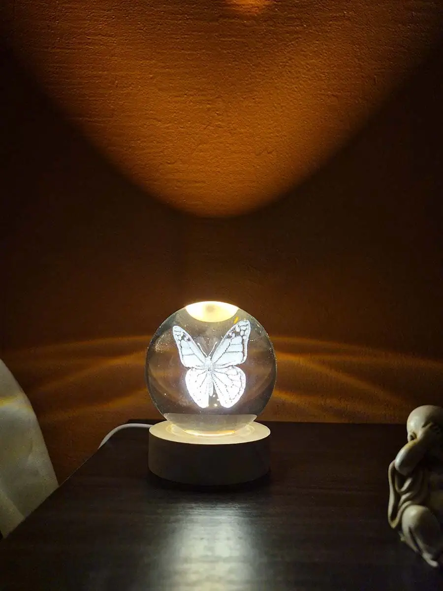 Lámpara esfera de cristal 3D con mariposa iluminada y base de madera
