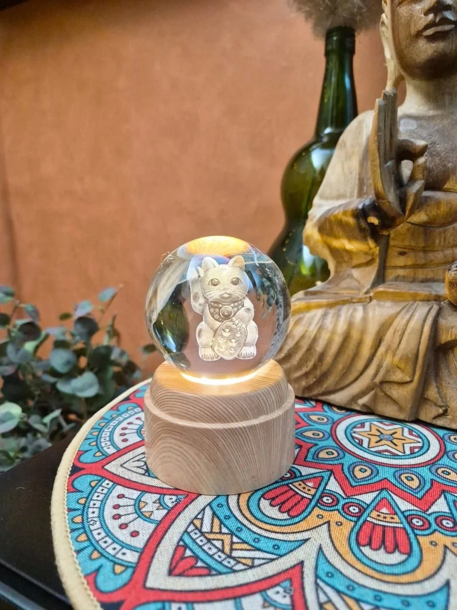 Lámpara esfera de cristal 3D giratoria con gato japonés Maneki Neko grabado e iluminado sobre base de madera
