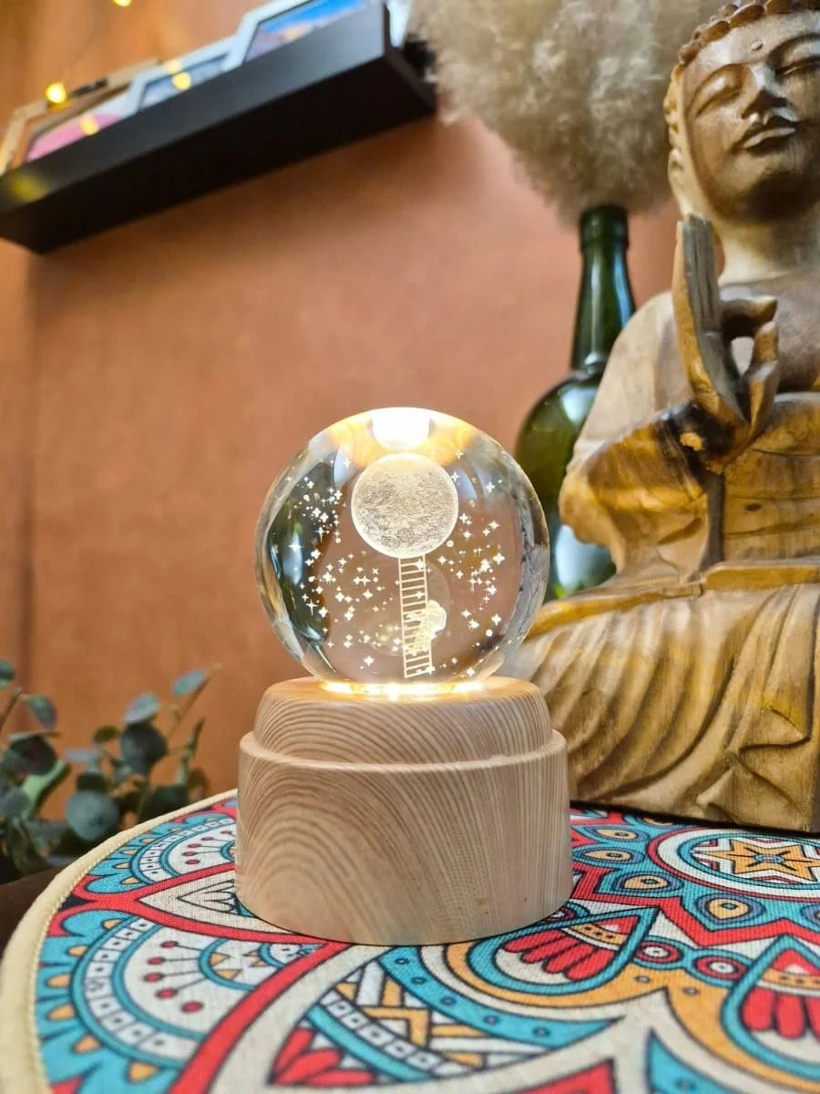 Lámpara esfera de cristal 3D giratoria con luna, estrellas y figura de un hombre sobre una escalera hacia la luna