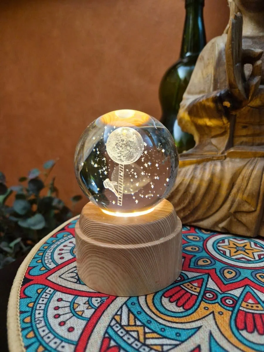 Lámpara esfera de cristal 3D giratoria con luna, estrellas y figura de un hombre sobre una escalera hacia la luna