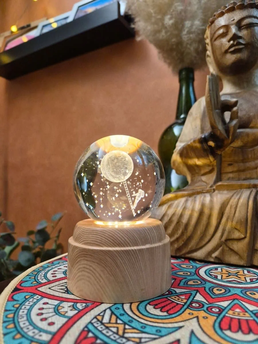 Lámpara esfera de cristal 3D giratoria con luna, estrellas y figura de un hombre sobre una escalera hacia la luna