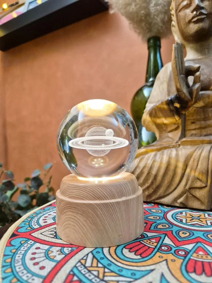 Lámpara esfera de cristal 3D giratoria con planeta Saturno y sus anillos grabados, iluminada con luz cálida