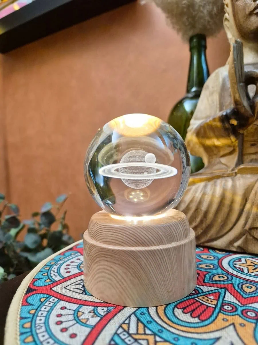 Lámpara esfera de cristal 3D giratoria con planeta Saturno y sus anillos grabados, iluminada con luz cálida