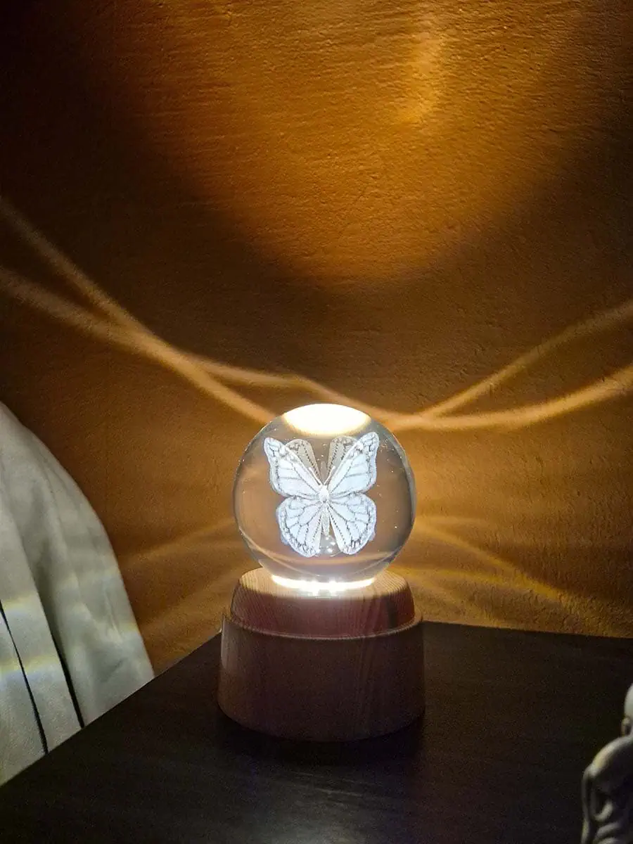 Lámpara esfera de cristal 3D giratoria con mariposa, luz cálida y base de madera