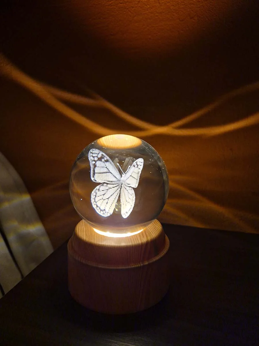 Lámpara esfera de cristal 3D giratoria con mariposa, luz cálida y base de madera