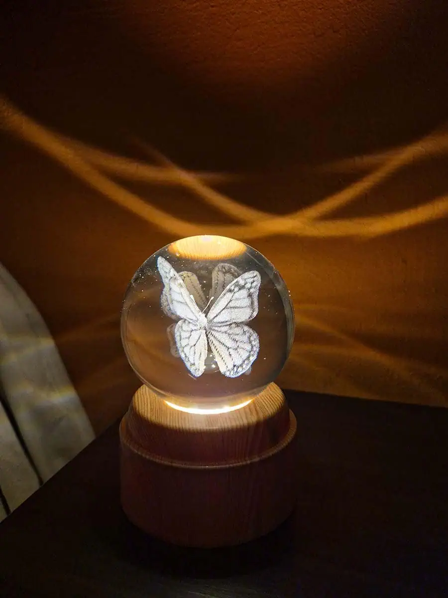 Lámpara esfera de cristal 3D giratoria con mariposa, luz cálida y base de madera