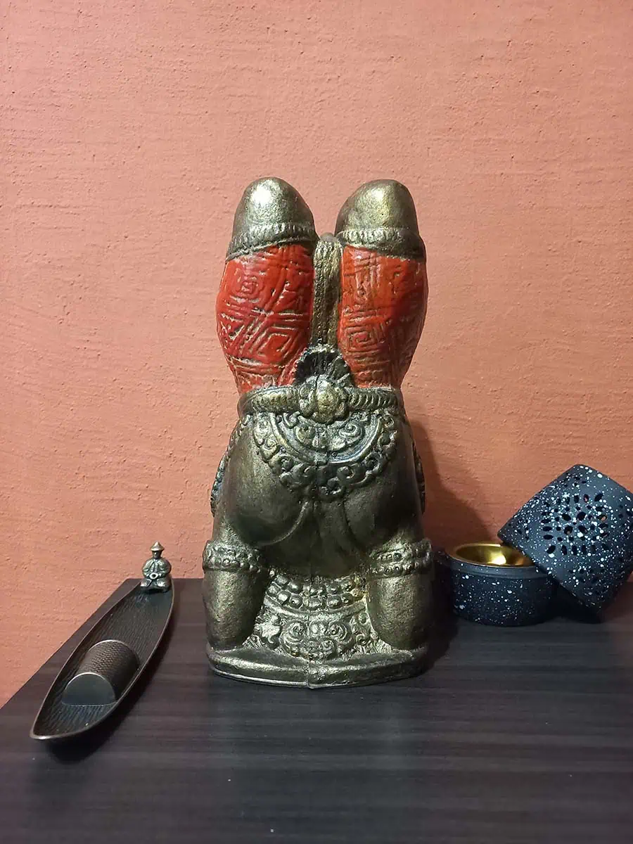 imagen de una ganesha decorativa haciendo yoga para la casa de color bronce con naranja