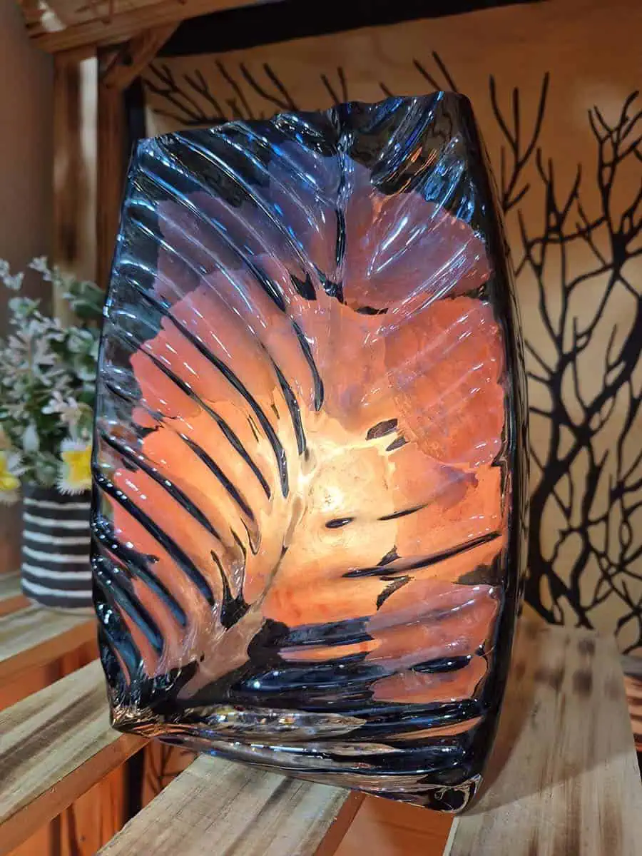 Lámpara de sal del Himalaya con piedras iluminadas dentro de un recipiente de vidrio con forma de flor