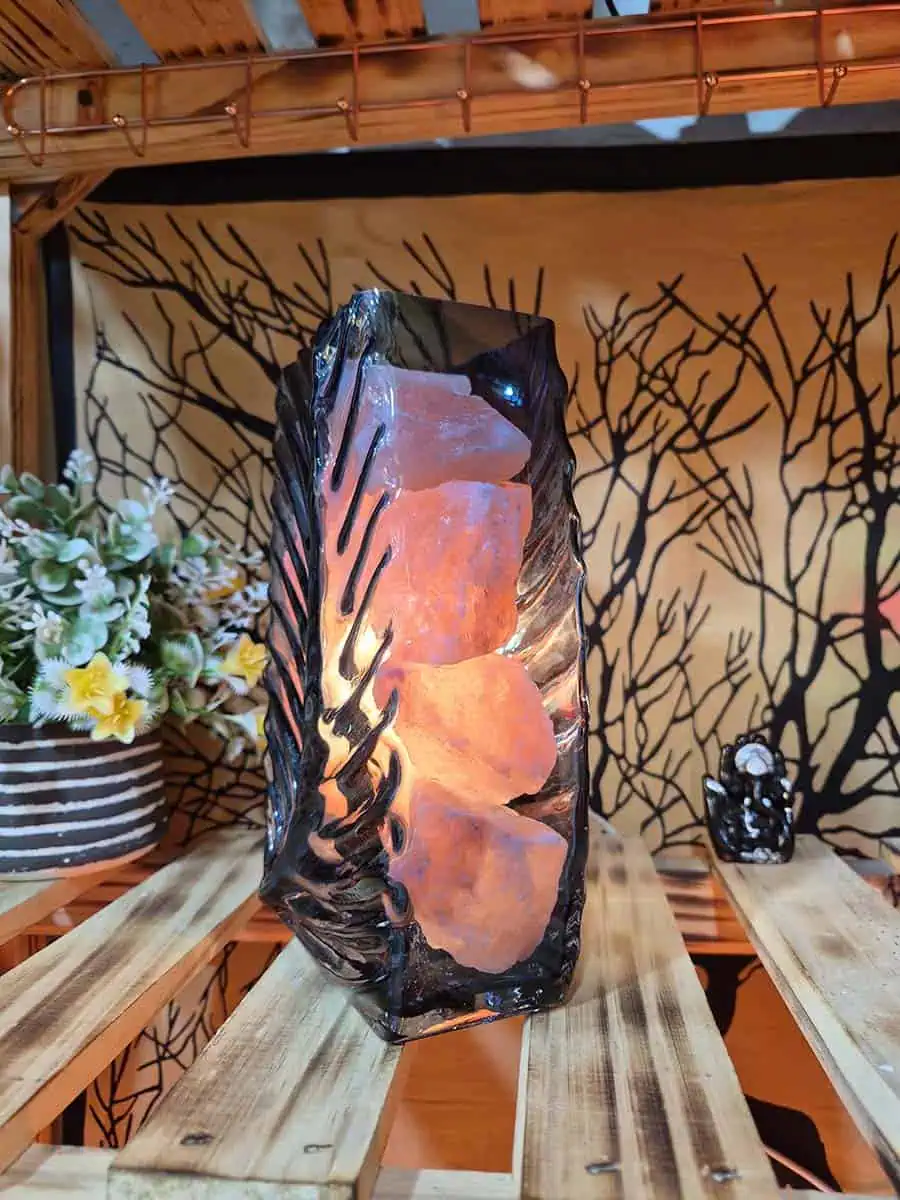 Lámpara de sal del Himalaya con piedras iluminadas dentro de un recipiente de vidrio con forma de flor