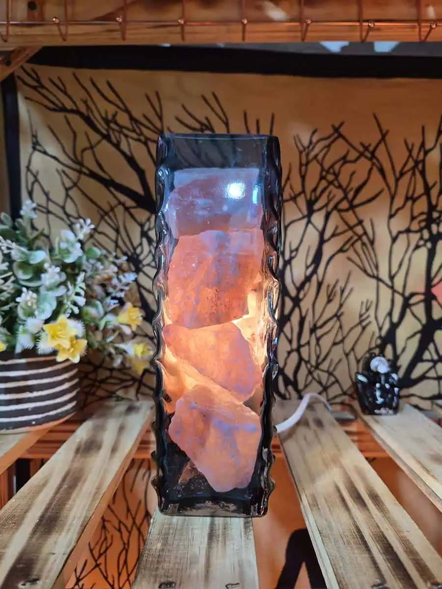 Lámpara de sal del Himalaya con piedras iluminadas dentro de un recipiente de vidrio con forma de flor