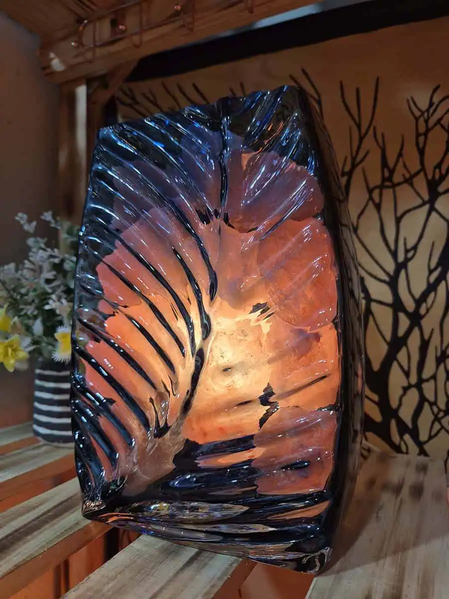 Lámpara de sal del Himalaya con piedras iluminadas dentro de un recipiente de vidrio con forma de flor