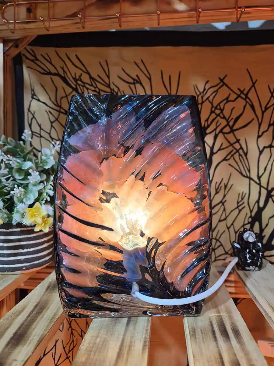 Lámpara de sal del Himalaya con piedras iluminadas dentro de un recipiente de vidrio con forma de flor
