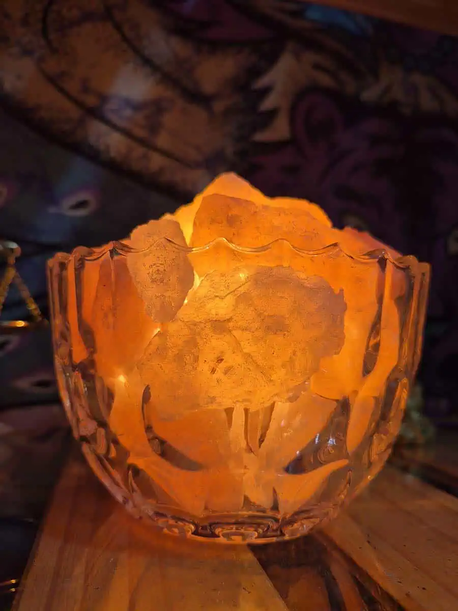Lámpara de sal del Himalaya con piedras iluminadas dentro de un cuenco redondo de vidrio transparente