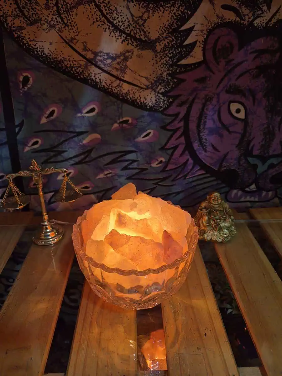 Lámpara de sal del Himalaya con piedras iluminadas dentro de un cuenco redondo de vidrio transparente
