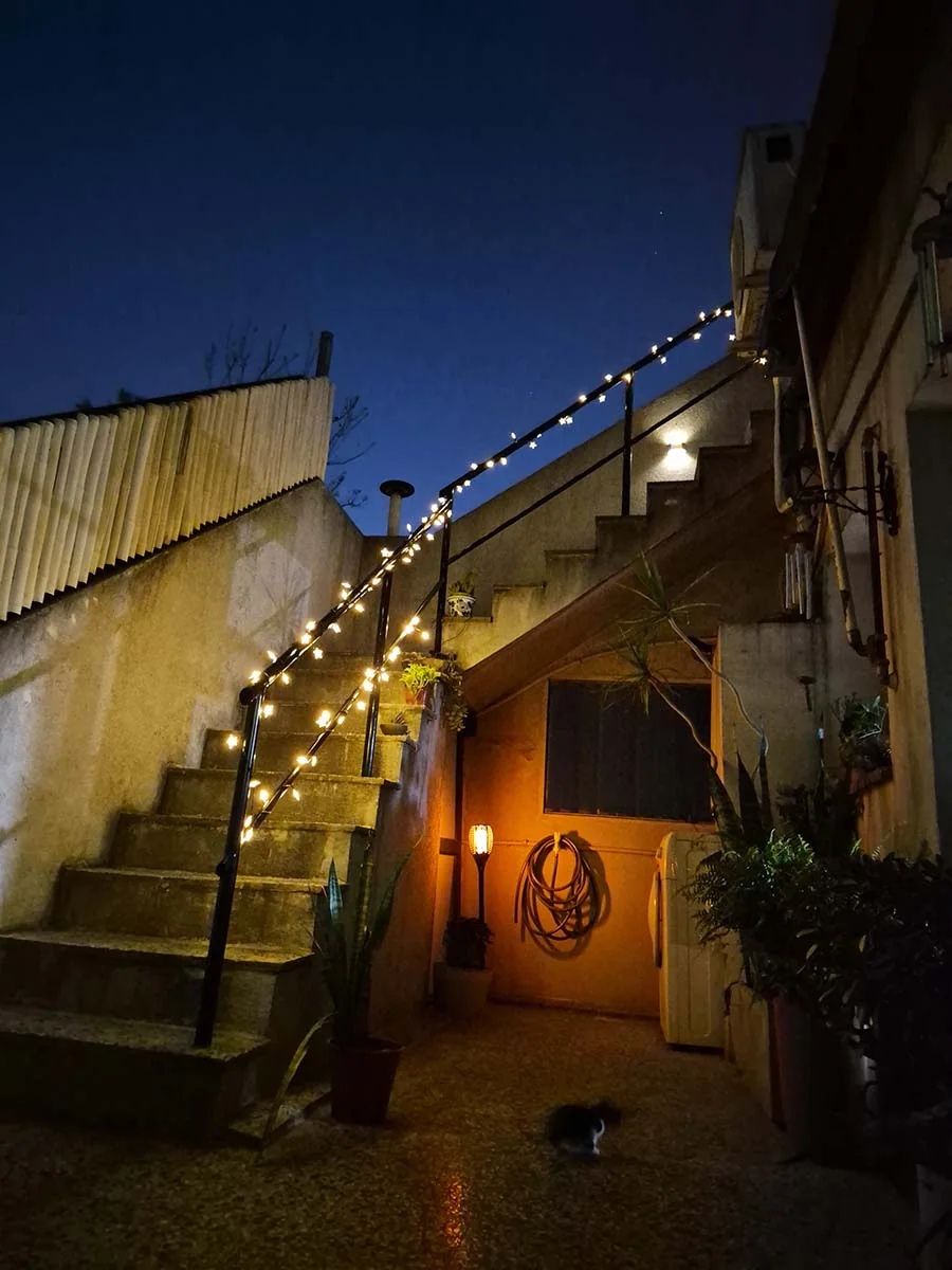 Guirnalda solar de estrellas con luz cálida de 10 metros decorando una escalera y su baranda exterior.